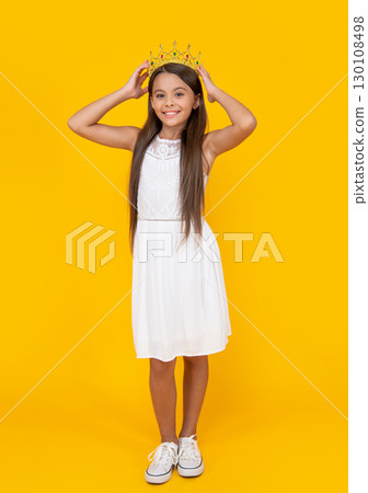 smiling teen kid in crown on yellow background 130108498