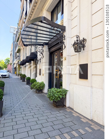 Side view of building entrance with canopy and street details. Concept of architecture, real estate, and urban lifestyle. 130108518