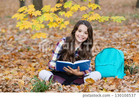 Autumn book. Back to school. School education. School girl reading book outdoor. Teen girl reading in the autumn park. Education and knowledge. Knowledge day. Self education. Clever college student Autumn book. Back to school. School education. School girl reading book outdoor. Teen girl reading in the autumn park. Education and knowledge. Knowledge day. Self education. Clever college student 130108537