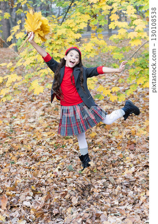 Girl in fall park wear uniform. Teen autumn uniform style. Autumn girl in school uniform in fall leaves outdoor. Stylish teen girl at school break. Back to school. Autumn leaves. Autumn sale 130108538