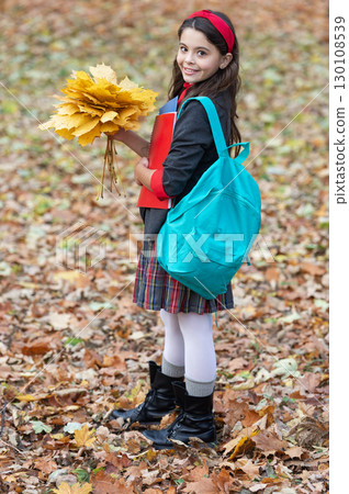 Stylish teen girl at school break. Back to school. Autumn fall leaves. Knowledge and education. Knowledge day. School education. Autumn girl in uniform hold fall leaves outdoor. Autumn sale Stylish teen girl at school break. Back to school. Autumn fall leaves. Knowledge and education. Knowledge day. School education. Autumn girl in uniform hold fall leaves outdoor. Autumn sale 130108539