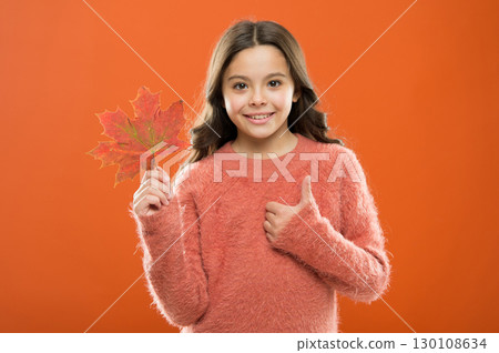 Satisfied kid show thumbs up. Little child hold maple leaf changing color. Celebrate autumn. Autumn is best season. Small girl smiling with autumn leaf and gesturing thumbs up. Thumbs up or like 130108634