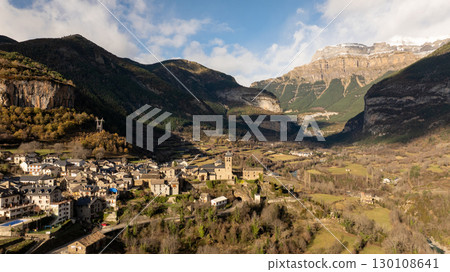 Scenic view of torla ordesa nestled in a valley, with the Pyrenees mountains rising in the background, showcasing the beauty of Huesca, Spain Scenic view of torla ordesa nestled in a valley, with the Pyrenees mountains rising in the background, showcasing the beauty of Huesca, Spain 130108641