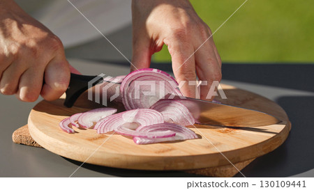 chef cuts fresh red onion on cutting board chef cuts fresh red onion on cutting board 130109441