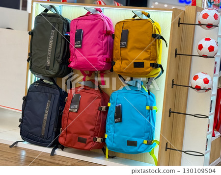 Store display with colorful backpacks on shelf. Concept of travel, mobility, lifestyle, and consumer fashion products. Store display with colorful backpacks on shelf. Concept of travel, mobility, lifestyle, and consumer fashion products. 130109504