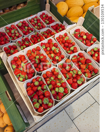 Fresh strawberries arranged in vibrant baskets at a local market Fresh strawberries arranged in vibrant baskets at a local market 130109534