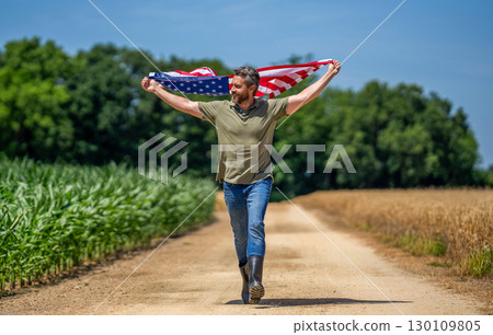 Independence day of America. 4th of July. American labor day. American flag and man farmer. Flag of USA. Independence day. Man in field. Man with American flag in crop field. Confidence in future Independence day of America. 4th of July. American labor day. American flag and man farmer. Flag of USA. Independence day. Man in field. Man with American flag in crop field. Confidence in future 130109805