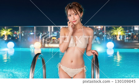 一位身穿比基尼的時尚女性站在夜景泳池的梯子上 一位身穿比基尼的時尚女性站在夜景泳池的梯子上 130109845