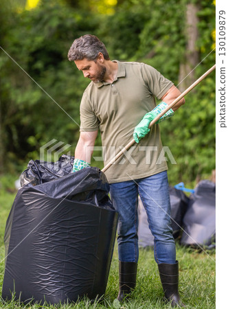 Save environment. Environment plastic pollution. Volunteer man collecting garbage in forest. Environmental protection. Man environmental activist. Environmental conservation. Overflowing bag Save environment. Environment plastic pollution. Volunteer man collecting garbage in forest. Environmental protection. Man environmental activist. Environmental conservation. Overflowing bag 130109879