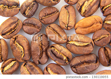 Up-close perspective of roasted coffee beans with visible splits and a smooth 130110055