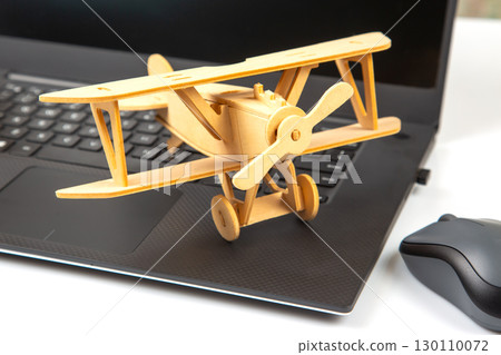 Model of a wooden plane on the background of a laptop 130110072