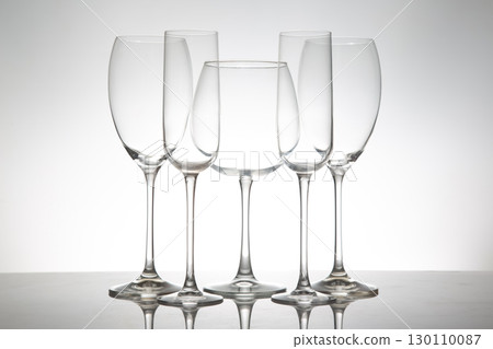 A minimalist display of five empty wine glasses  130110087