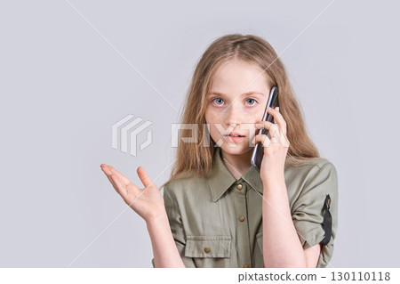 Caucasian female child talking on smartphone with confused expression in casual Caucasian female child talking on smartphone with confused expression in casual 130110118