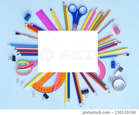 white sheet of paper and a school stationery around on a blue background white sheet of paper and a school stationery around on a blue background 130110198