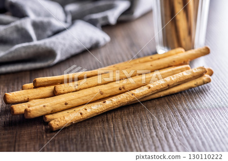 Crispy grissini breadsticks on wooden table. 130110222