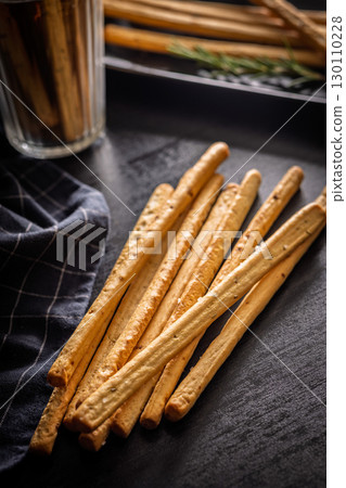 Crispy grissini breadsticks on black table. 130110228