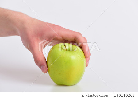 Male hand holds green apple. Apple in fresh juicy color 130110265