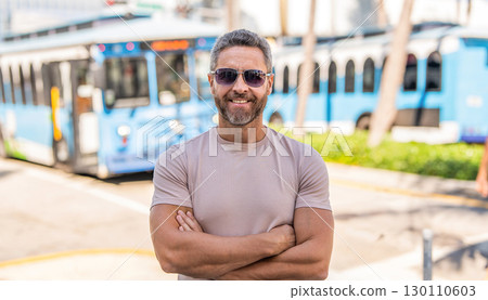 Summer style man has bus trip. Mature tourist at bus station. Tourist man on city street. Traveler tourist man in casual clothes with sunglasses. Man travel lifestyle. Tourist in summer city Summer style man has bus trip. Mature tourist at bus station. Tourist man on city street. Traveler tourist man in casual clothes with sunglasses. Man travel lifestyle. Tourist in summer city 130110603