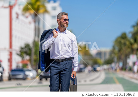Corporate business. Rich businessman in suit. Business portrait. Successful businessman walking with briefcase outdoor. Businessman hold briefcase. Businessman after successful deal. Inspiring leader 130110668