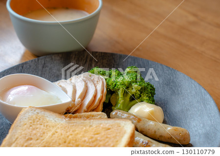 Breakfast of toast, chicken ham, sausage, soft-boiled egg, and soup 130110779