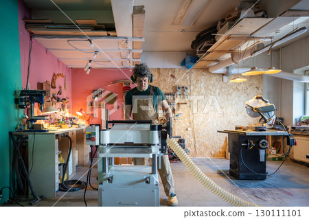 Band saw machine operating. Concentrated craftsman woodworking in studio, finalizing project 130111101