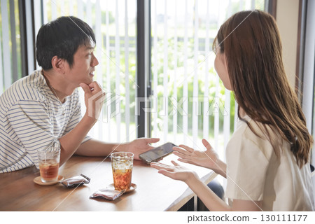 Men and women smiling and talking while looking at their smartphones 130111177