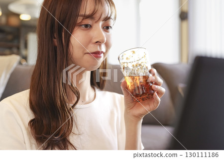 A woman who operates a personal computer in the living room A woman who operates a personal computer in the living room 130111186