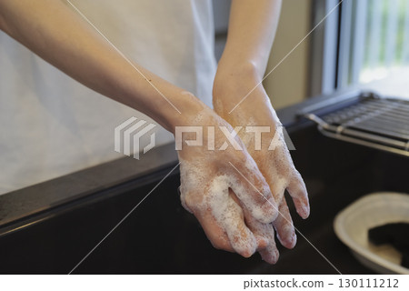 Woman washing her hands in the kitchen (no face) Woman washing her hands in the kitchen (no face) 130111212