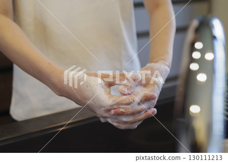 Woman washing her hands in the kitchen (no face) 130111213