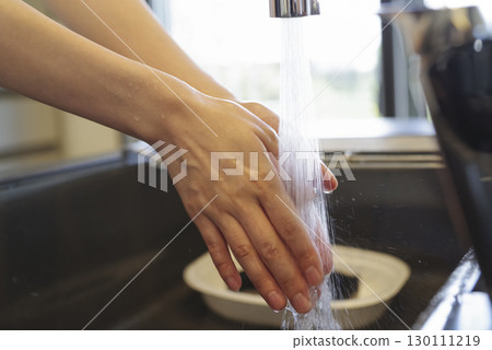 Woman washing her hands in the kitchen (no face) 130111219