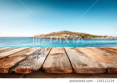 Wooden table over still sea with verdant island, blue sky. Suitable for travel, nature, product backdrop. 130111234