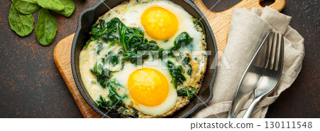 Healthy spinach omelette in cast iron pan top view 130111548