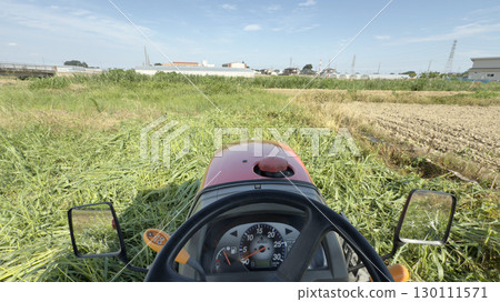 Shooting from the driver's seat of a tractor, plowing a field of grass 130111571