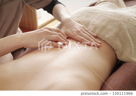 Therapist giving back massage 130111966