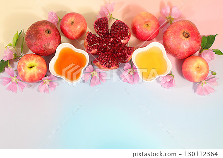 Autumn banner with honey, apples, pomegranates, flowers, dried fruits for holiday greeting, composition for Jewish holiday Rosh Hashanah with traditional symbols, creative layout for design, template 130112364