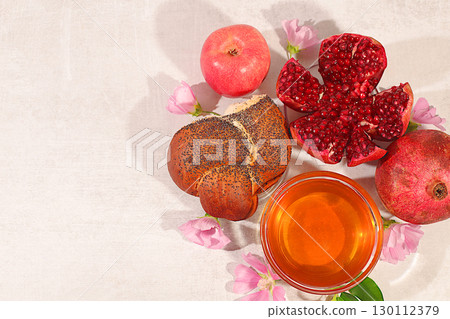 Creative composition for the Jewish holiday Ro Hashanah with a place for congratulations. Layout with traditional symbols of the Jewish New Year, template with honey, apples, pomegranate and flowers 130112379