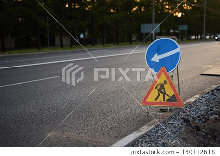 A Construction Zone Sign is prominently displayed on a road during the twilight hours at dusk 130112618