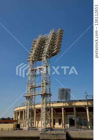 Striking Illuminated Sports Structure Set Against a Clear and Vibrant Blue Sky Background 130112653