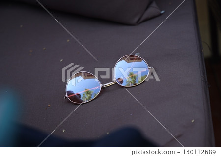 Sunglasses Placed on a Couch That Beautifully Reflects Nature and Its Surroundings 130112689