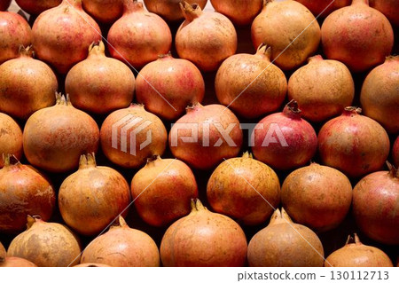 Fresh pomegranates in a market showcase their beauty and delicious appeal, inviting all Fresh pomegranates in a market showcase their beauty and delicious appeal, inviting all 130112713
