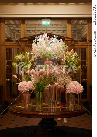 An Elegant, Beautiful, and Striking Floral Arrangement Set in a Charming Hotel Lobby Atmosphere An Elegant, Beautiful, and Striking Floral Arrangement Set in a Charming Hotel Lobby Atmosphere 130112733