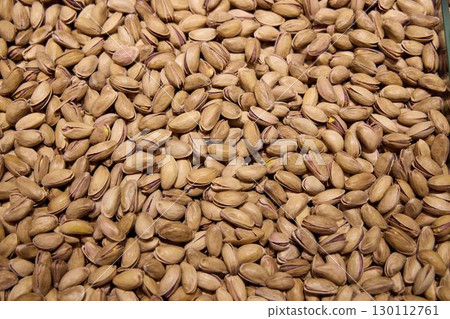 The varied texture of shelled pistachios and nuts creates a delightful background 130112761