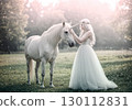 Fantasy landscape of a woman in a white dress touching a unicorn 130112831