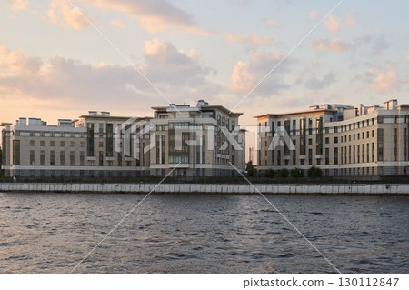 Stunning and Modern Waterfront Buildings Silhouetted Against a Beautiful Sunset Sky 130112847