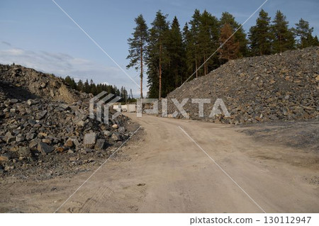 A Beautiful Scenic Gravel Pathway that is Enveloped by a Mix of Stones and a Lush Forest A Beautiful Scenic Gravel Pathway that is Enveloped by a Mix of Stones and a Lush Forest 130112947