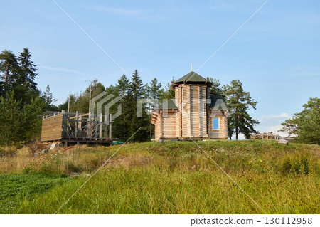 A Scenic Wooden Chapel Nestled and Surrounded by Nature in a Peaceful, Tranquil Landscape A Scenic Wooden Chapel Nestled and Surrounded by Nature in a Peaceful, Tranquil Landscape 130112958