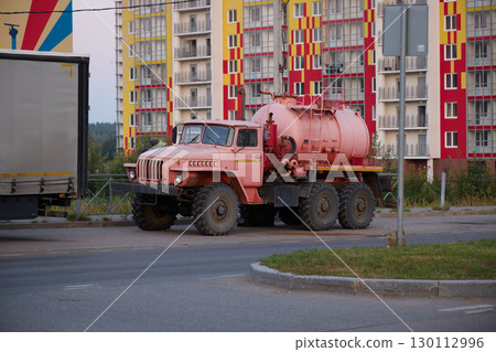 A Vintage Pink Water Tank Truck Set In An Urban Environment Full Of Life And Character 130112996