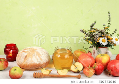 Autumn composition with apples, honey, pomegranate and candle. Harvesting concept, Jewish New Year Rosh Hashanah background, ecological food. Healthy eating, body detoxification, selective focus 130113040