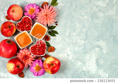 Autumn banner with honey, apples, pomegranates, flowers, dried fruits on concrete background, composition for Jewish holiday Rosh Hashanah, autumn greeting and thanksgiving concept, selective focus, 130113055