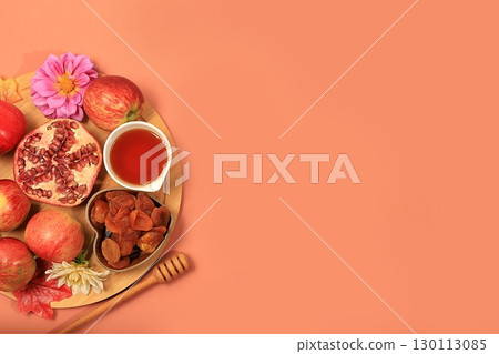 Autumn banner with honey, apples, pomegranates, flowers, dried fruits on a warm orange background, composition for the Jewish holiday Rosh Hashan, space for text, Hello autumn and thanksgiving day 130113085